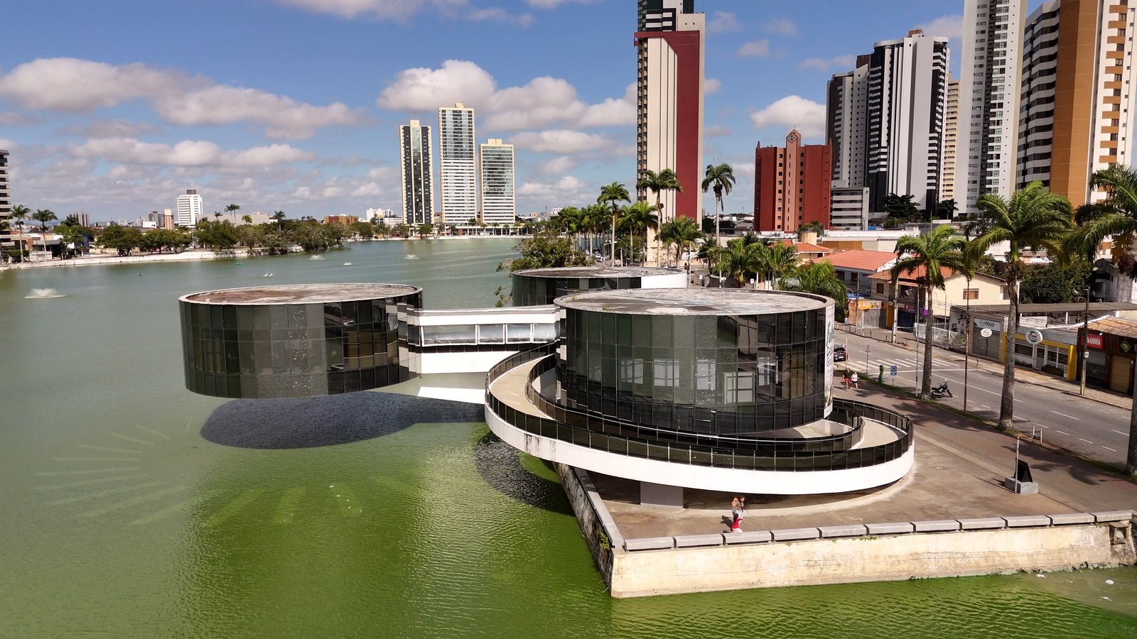 Imagem aérea do Açude Velho, em Campina Grande, com o Museu de Arte Popular da Paraíba sobre a água e os prédios ao fundo