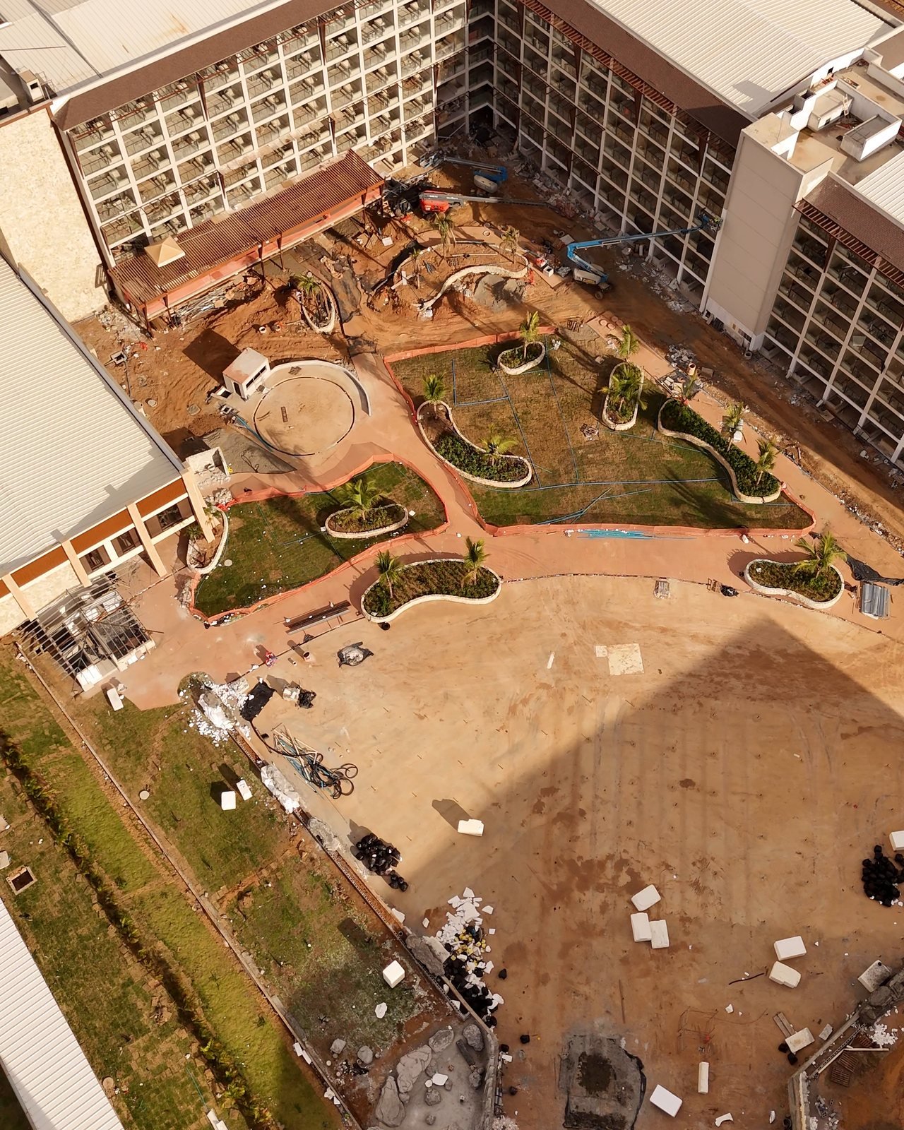 Vista aérea vertical da área de lazer do Tauá Resort em construção, com jardins, caminhos e piscinas entre os blocos de apartamentos