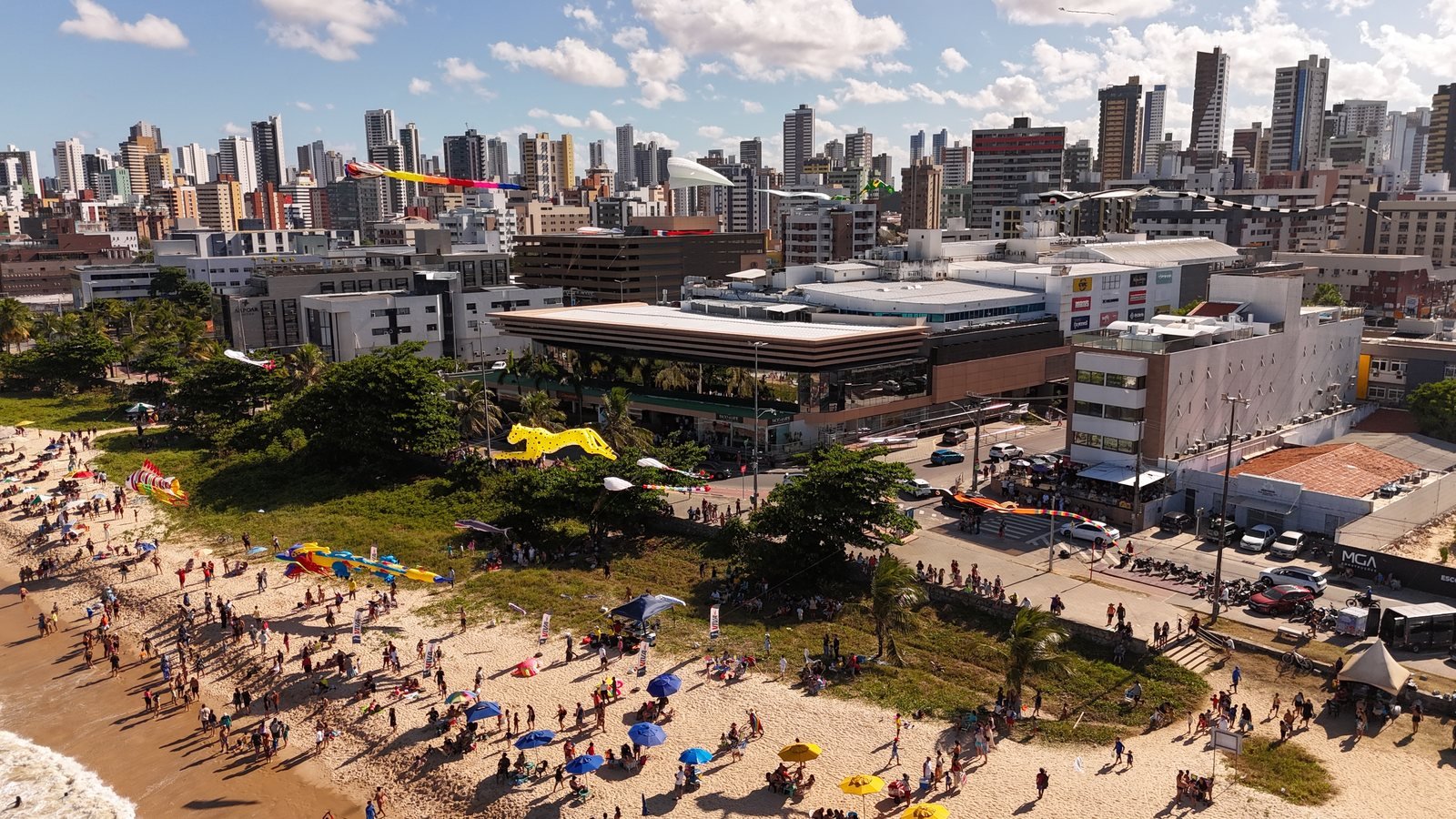 Vista aérea do início do Festival de Pipas Gigantes, com as pipas sendo armadas na areia de Manaíra e o público chegando