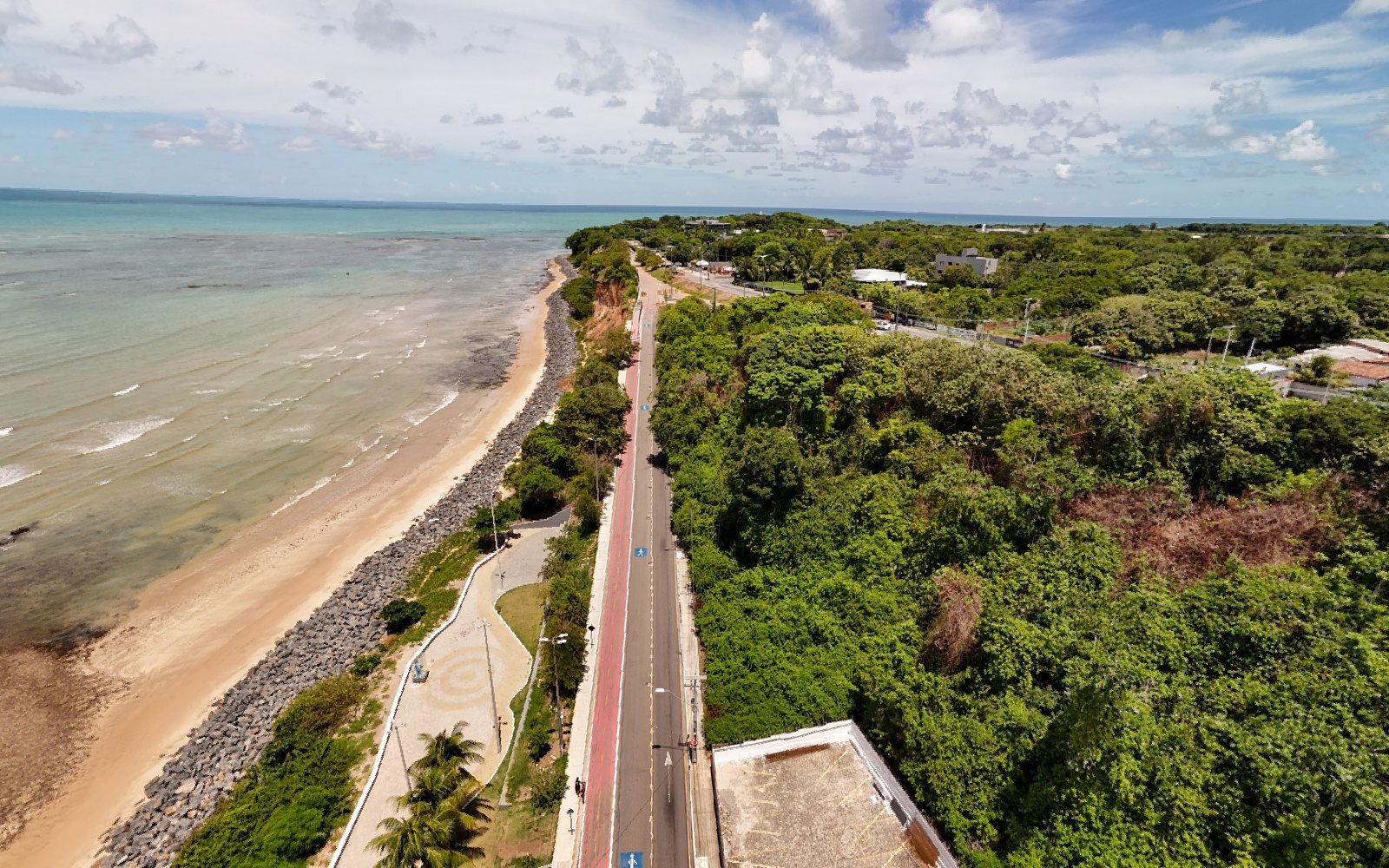 Vista aérea da avenida subindo a falésia do Cabo Branco, com a ciclovia, a mata e os arrecifes ao lado