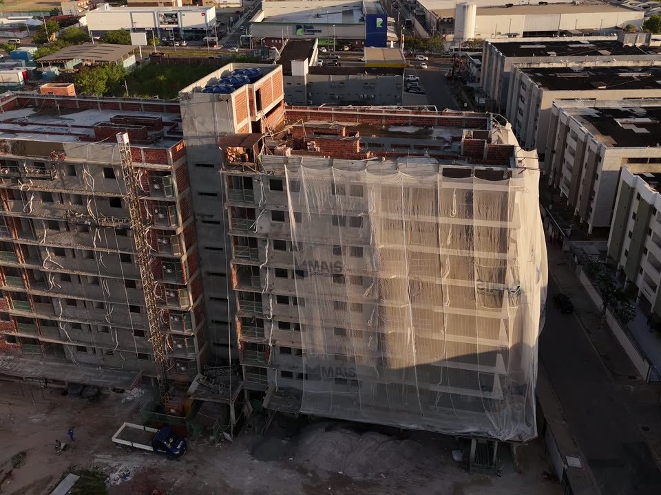 Imagem aérea de um prédio em construção em João Pessoa, com a tela de proteção na fachada